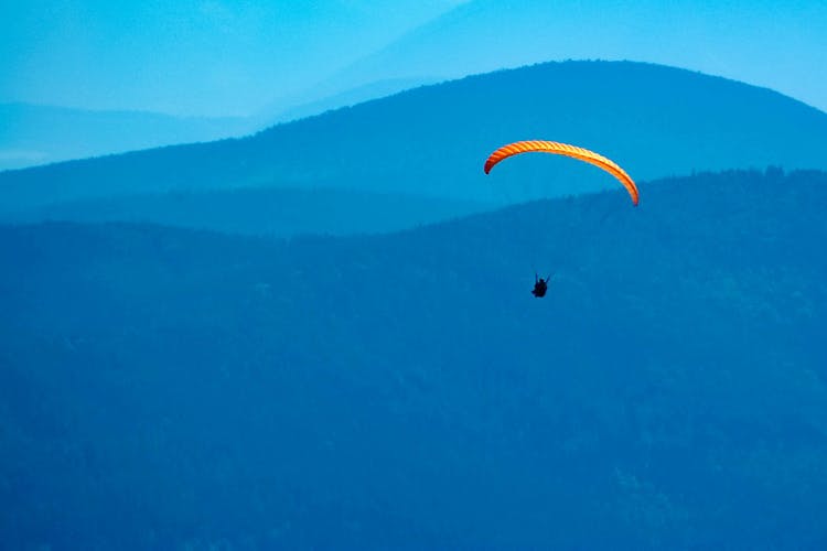 Paragliding,Air sports,Parachute,Parachuting,Sky,Blue,Daytime,Azure,Hill,Windsports