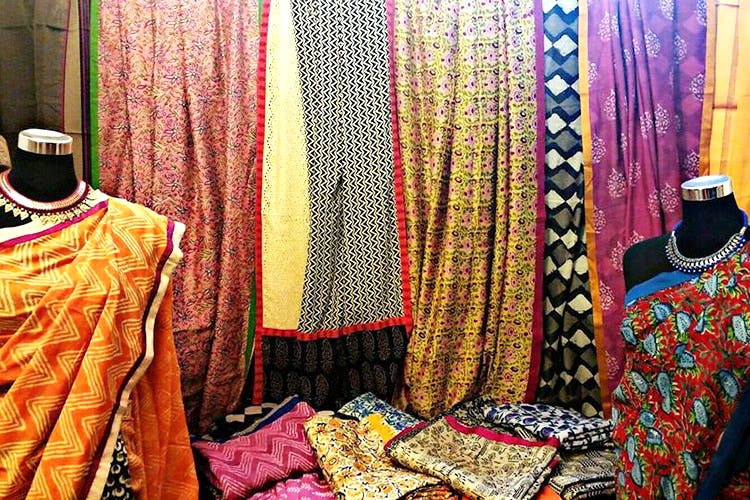 Boutique,Clothing,Room,Textile,Pink,Yellow,Magenta,Formal wear,Bazaar,Interior design