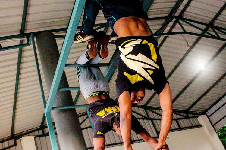 Yellow,Leg,Flip (acrobatic),Architecture,Acrobatics,Physical fitness,Performance,Street stunts,Ceiling,Human leg