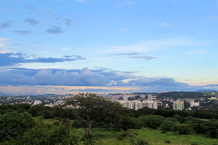 Sky,Cloud,Vegetation,Blue,Urban area,Daytime,Mountainous landforms,Hill,City,Mountain