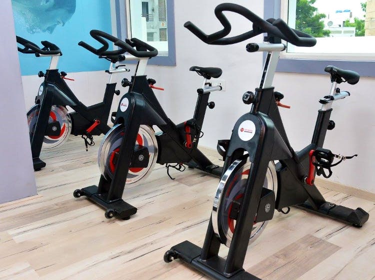 Indoor cycling,Stationary bicycle,Exercise equipment,Exercise machine,Exercise,Room,Gym,Sports equipment,Bicycle accessory,Vehicle