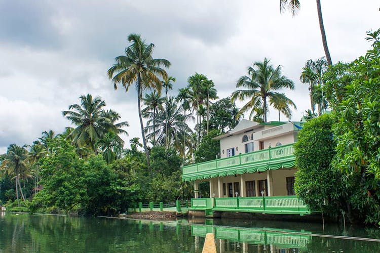 Vegetation,Tree,Water,Palm tree,Natural environment,House,Arecales,Tropics,Sky,Botany