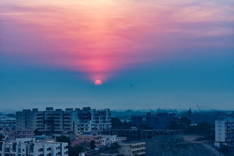 Sky,Cloud,Daytime,Urban area,Blue,Horizon,Metropolitan area,City,Atmospheric phenomenon,Sunset