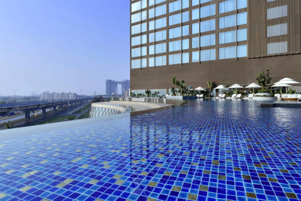 Architecture,Swimming pool,Reflecting pool,Building,Reflection,Water,Hotel,City,Condominium,Tile