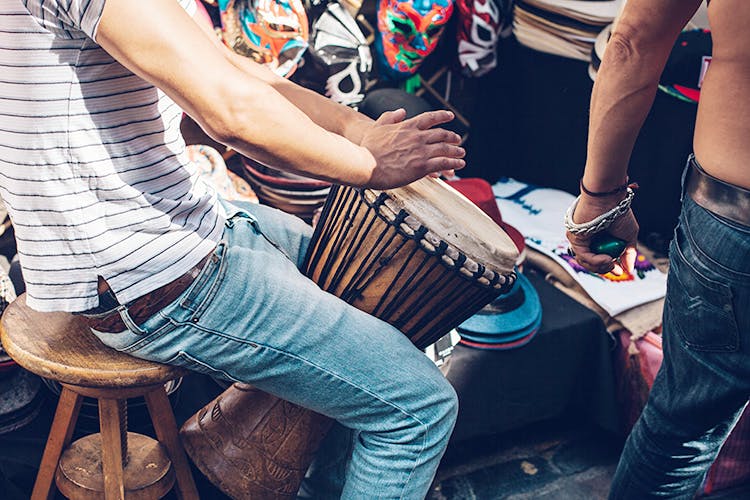 Drum,Djembe,Hand drum,Musical instrument,Hand,Membranophone,Percussion,Musician,Jeans,Flesh