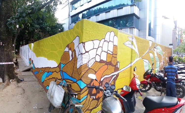 Street art,Graffiti,Wall,Art,Yellow,Mural,Urban area,Tree,Architecture,Visual arts
