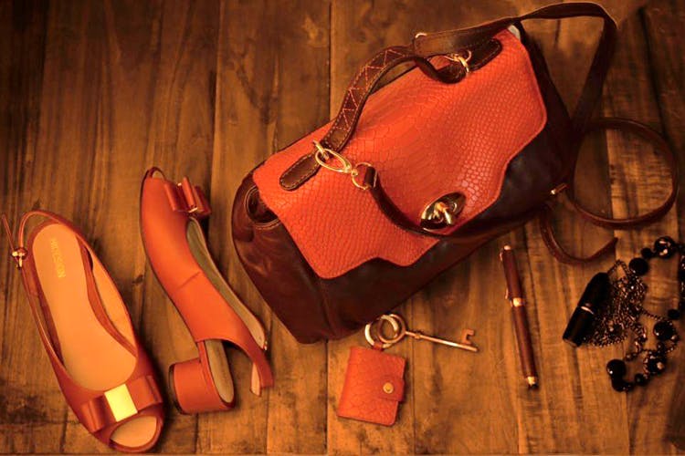 Red,Orange,Leather,Bag,Footwear,Fashion accessory,Personal protective equipment,Shoe,Still life photography,Still life
