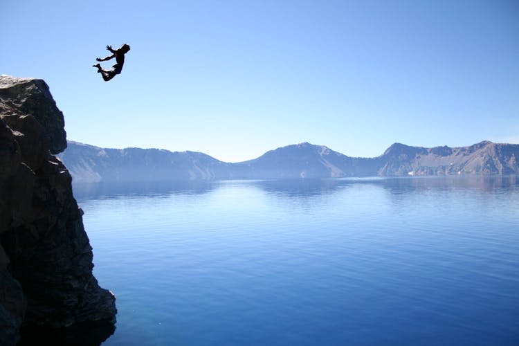 Sky,Extreme sport,Lake,Reflection,Cliff,Mountain,Terrain,Flip (acrobatic),Horizon,Calm