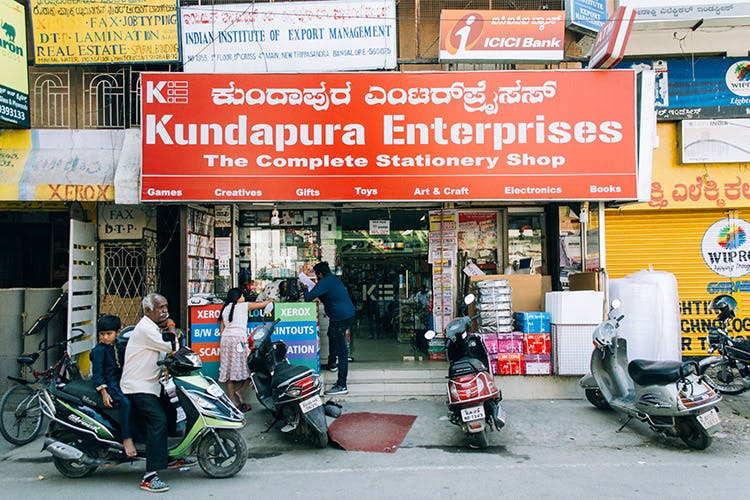 Building,Mode of transport,Vehicle,Street,Convenience store,Scooter,Signage,Retail,Advertising