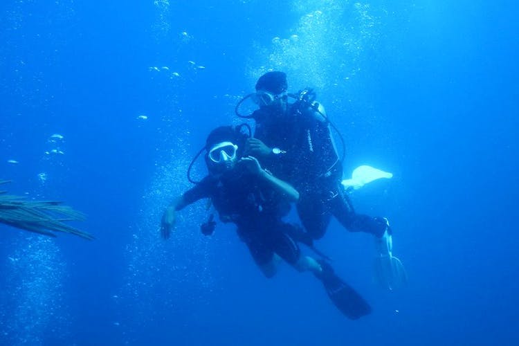Scuba diving,Divemaster,Underwater diving,Diving equipment,Dry suit,Underwater,Water,Aquanaut,Recreation,Buoyancy compensator