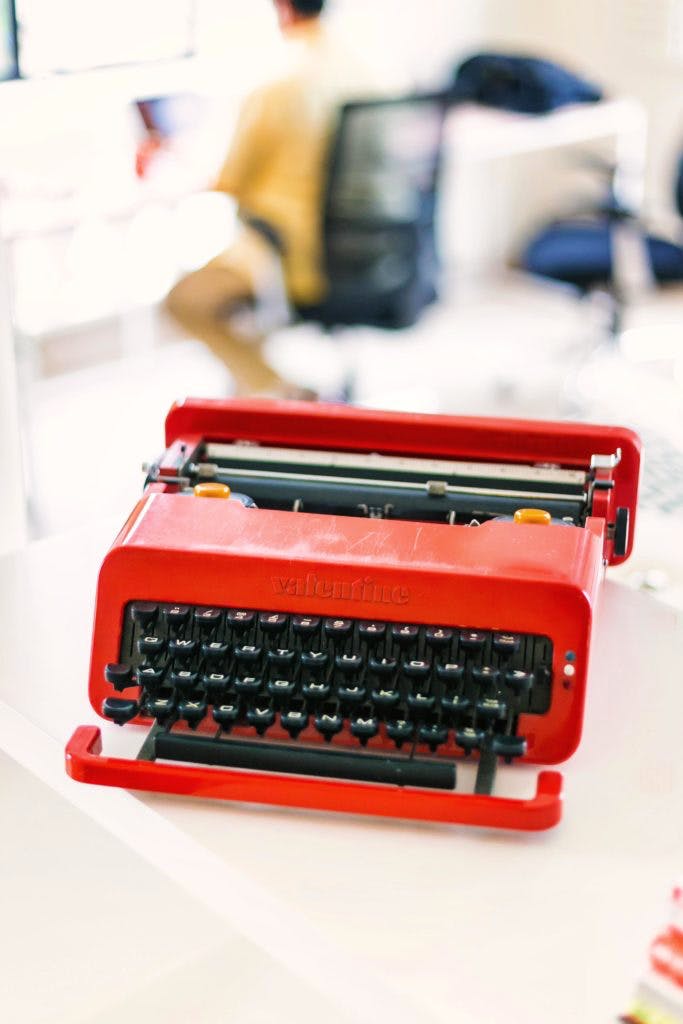 Typewriter,Office equipment,Red,Office supplies,Space bar,Orange,Technology