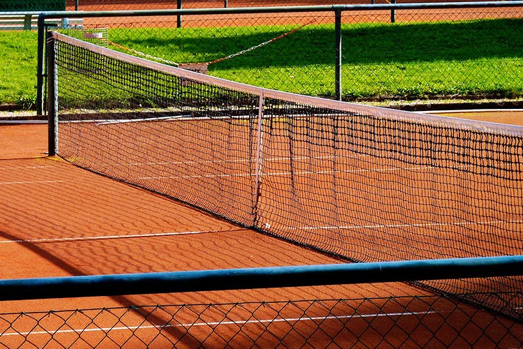 Tennis court,Sport venue,Net,Line,Chain-link fencing,Tennis,Grass,Fence,Tree,Wire fencing
