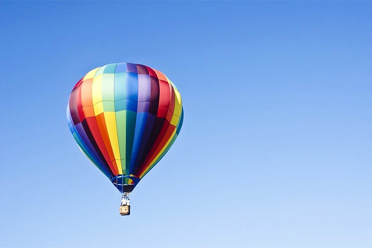 Hot air balloon,Hot air ballooning,Sky,Air sports,Blue,Daytime,Air travel,Mode of transport,Balloon,Vehicle