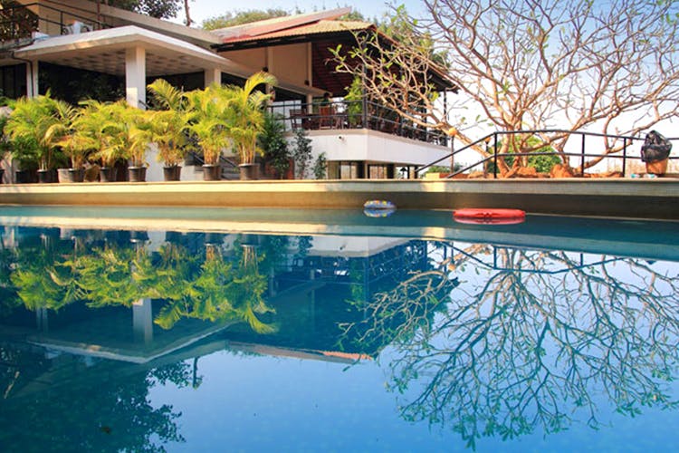 Reflection,Swimming pool,Water,Reflecting pool,Property,Architecture,Resort,Tree,House,Leisure