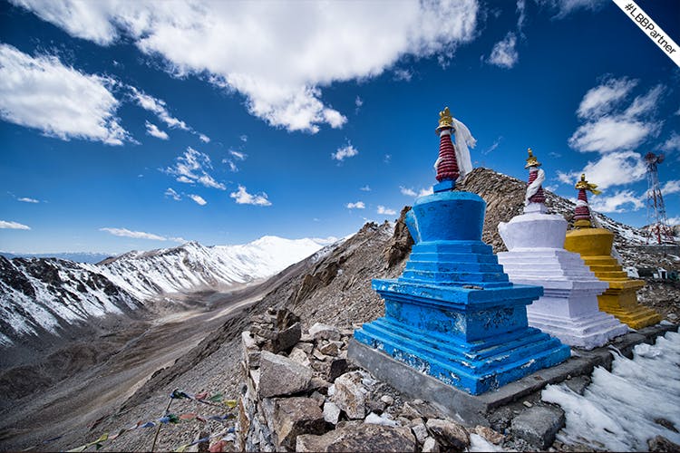 Sky,Blue,Mountain,Cloud,Stupa,Mountainous landforms,Place of worship,Mountain range,Summit,Snow